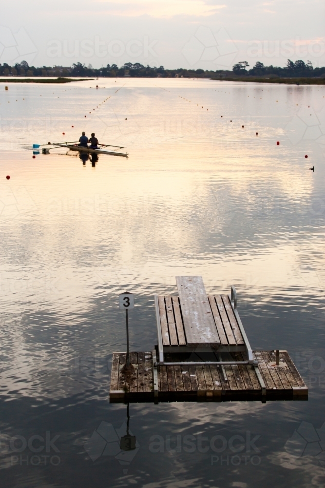 Rowers training on a lake in the evening - Australian Stock Image