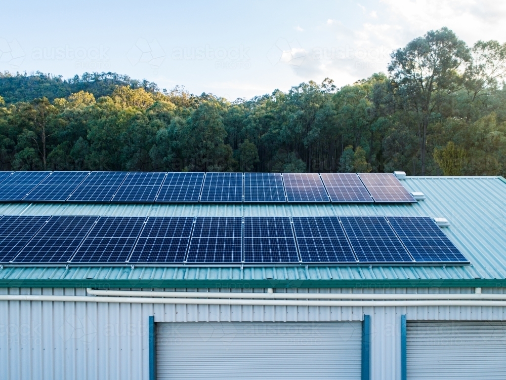 Rows of solar panels installed on house shed roof in rural area - Australian Stock Image