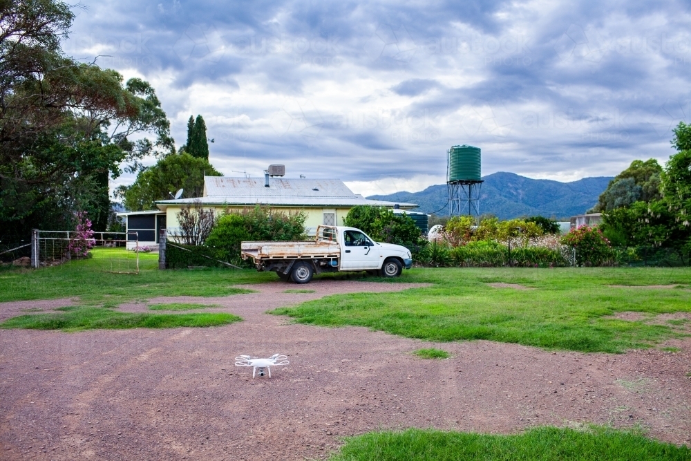 RPA drone on gravel driveway outside rural farmhouse on country property - Australian Stock Image