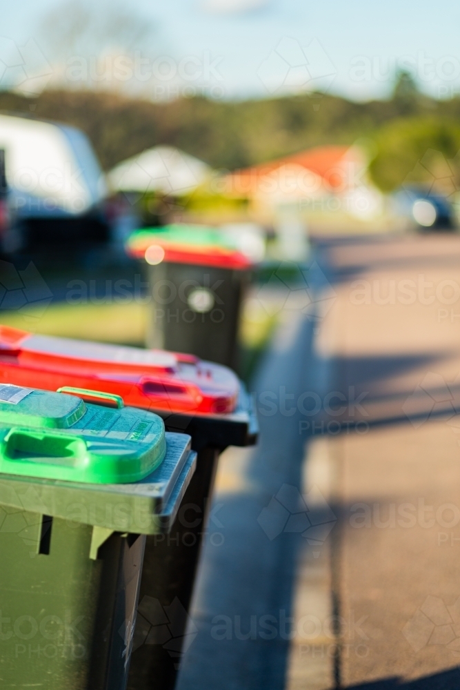 Rubbish and green bins out on quiet town street awaiting collection - Australian Stock Image