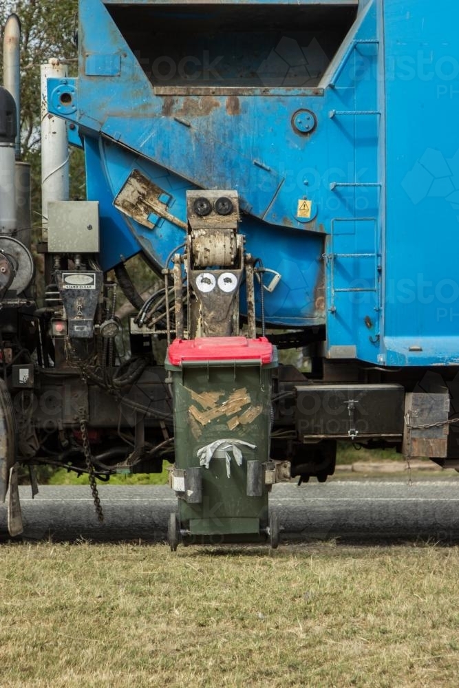 Image of Rubbish from a garbage bin being collected by the garbage