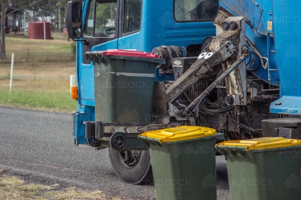 Rubbish from bins being collected by garbage truck - Australian Stock Image