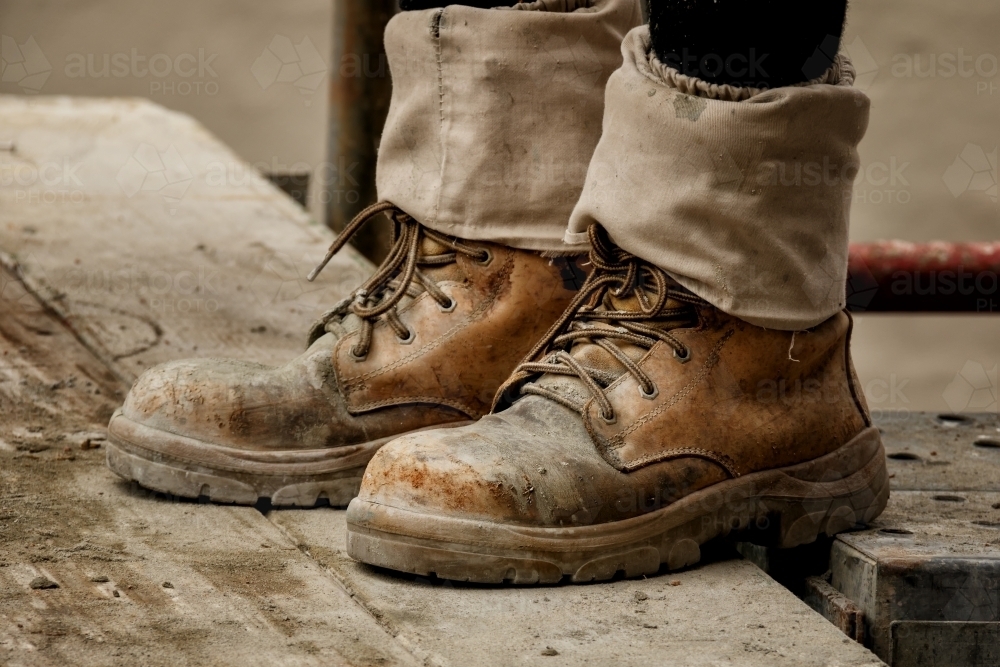 Rugged pair of brown tradesman's workboots on building site - Australian Stock Image