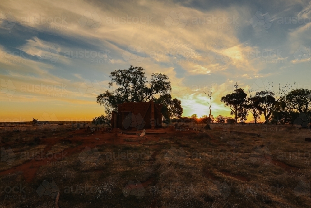 Ruins of abandoned mud brick home on rural property at sunset - Australian Stock Image