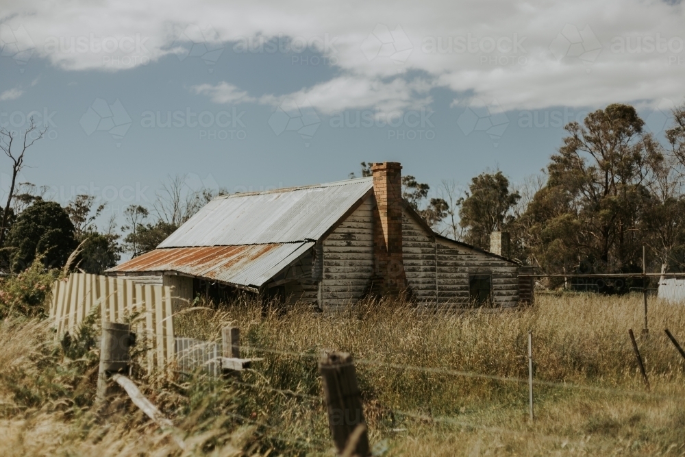 Run down old farmhouse, paddocks, blue sky and white clouds - Australian Stock Image