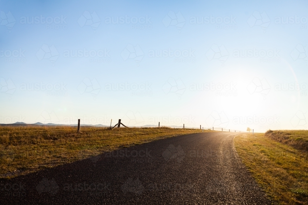 Rural country road towards the sunset and big open sky - Australian Stock Image