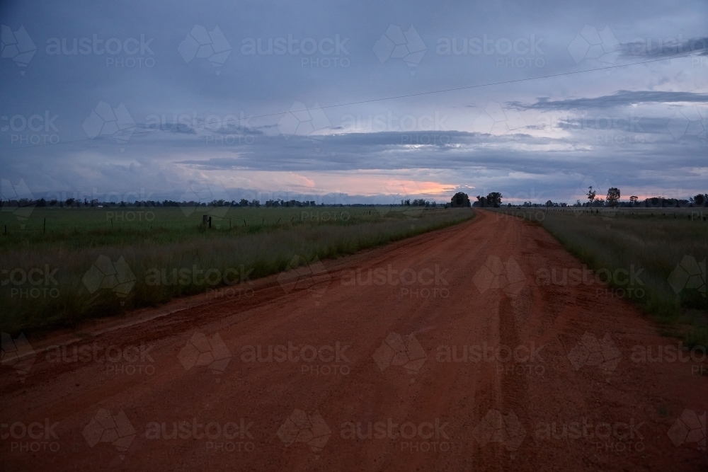 Rural dirt road and surrounding farmland on sunset - Australian Stock Image