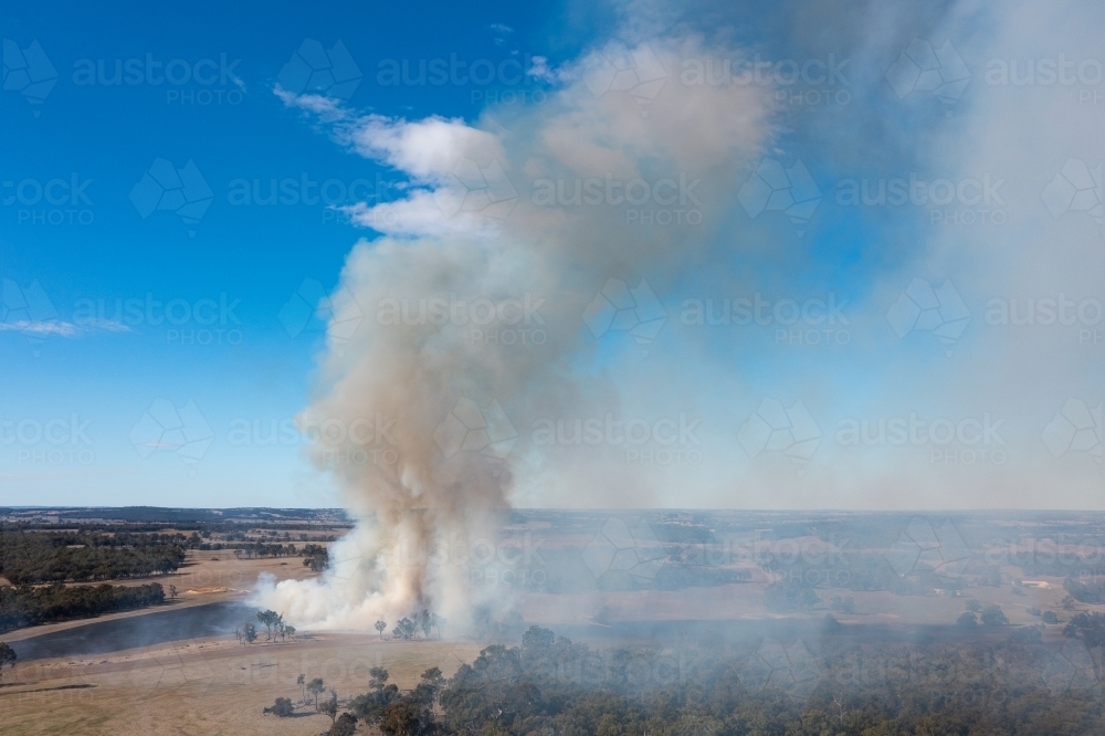 Image of rural landscape with smoke rising from dry farmland - Austockphoto