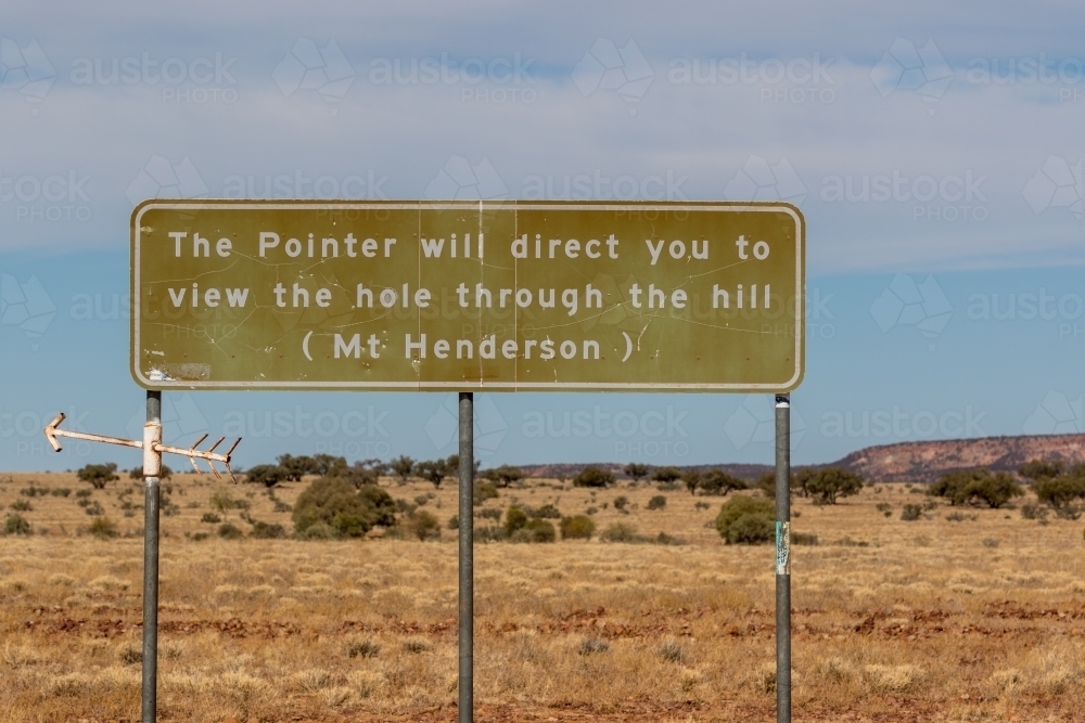 Rural road sign with a pointer directing to a view of a hole in a hill. - Australian Stock Image