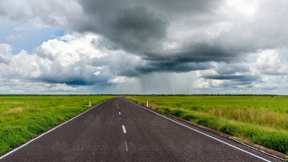 Rural road with green paddocks and stormy sky - Australian Stock Image