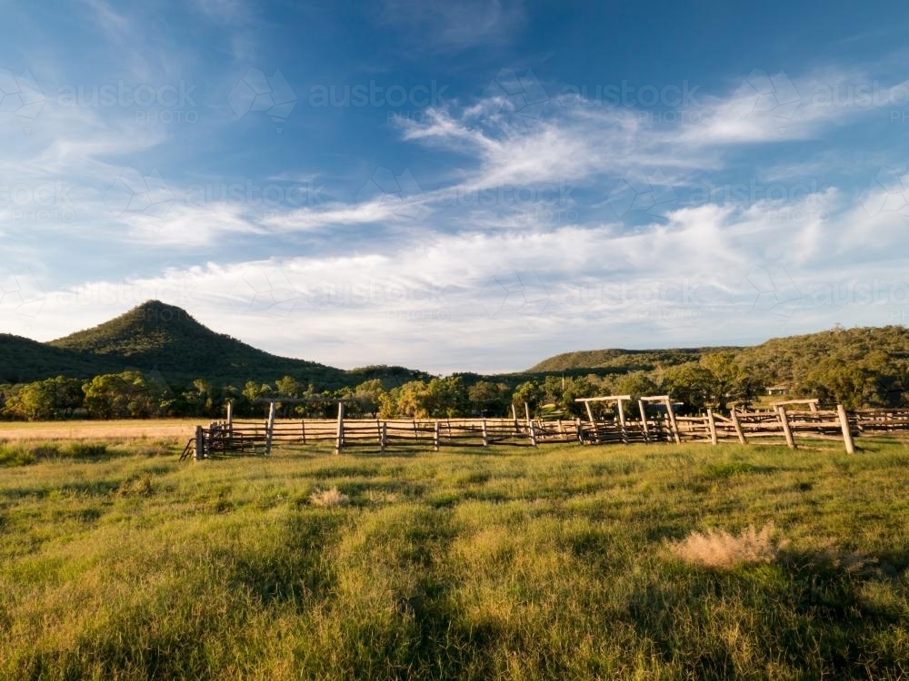Rural view of stockyards with hills in the background - Australian Stock Image
