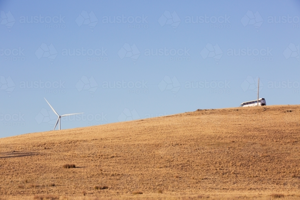 Rural Wind Turbines in a farm setting with bus on hilltop - Australian Stock Image
