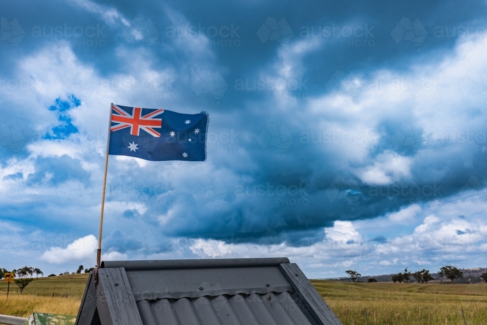 Rustic roadside mailbox in remote area of country New South Wales with Australian flag flying - Australian Stock Image