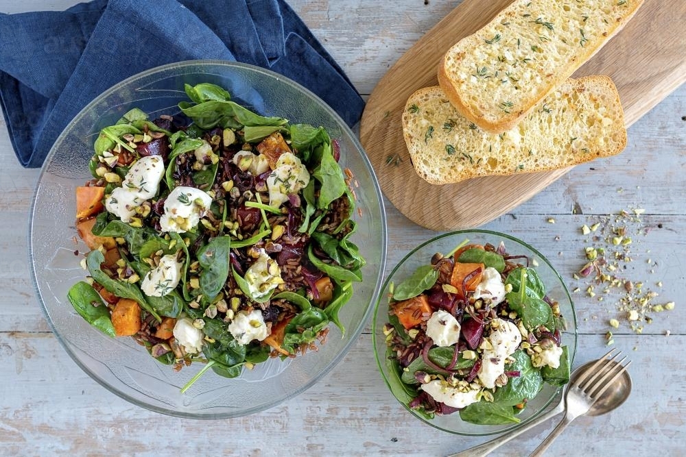 Rustic salad in bowls on table with toast - Australian Stock Image