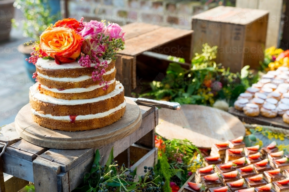 Rustic sponge cake at birthday with flowers - Australian Stock Image