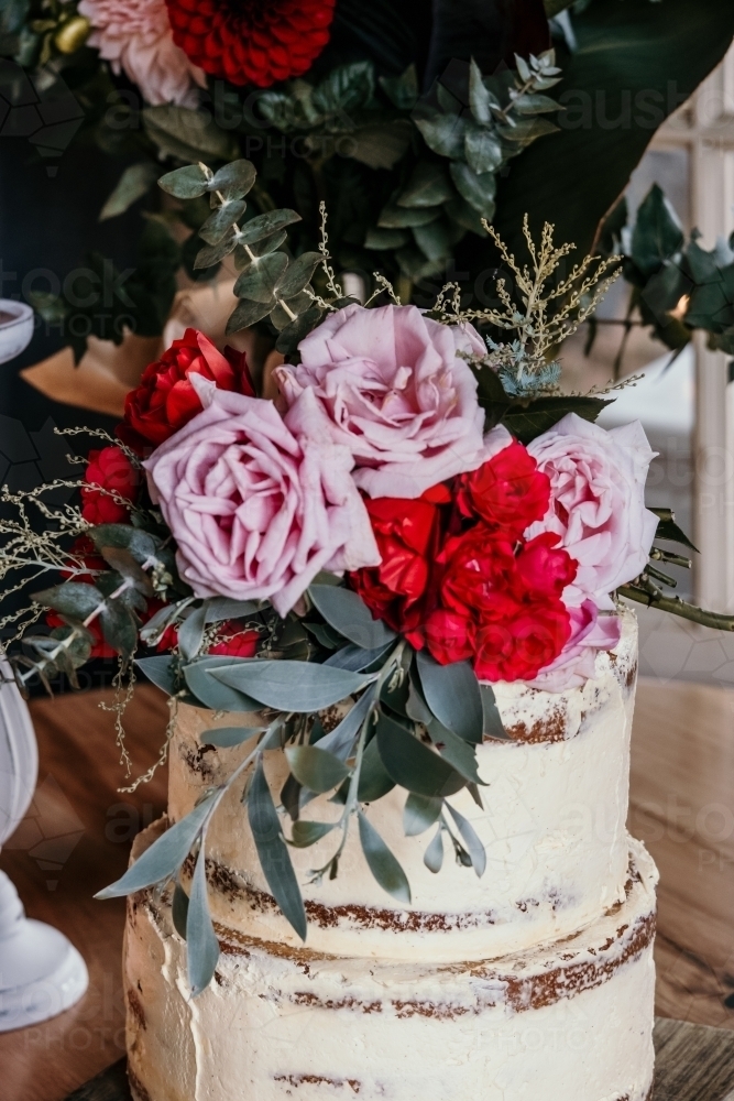 Image of Rustic wedding cake with fresh flower topper. Austockphoto