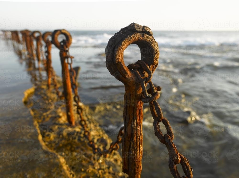 Rusting posts and chains along ocean pool - Australian Stock Image