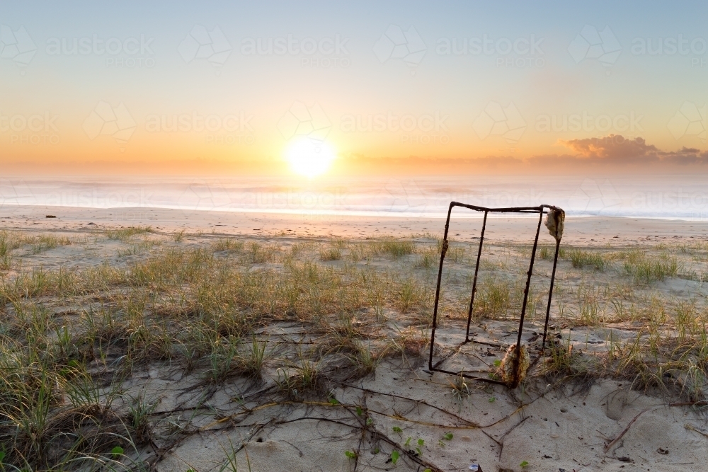 Rusty metal frame on the beach at sunrise - Australian Stock Image