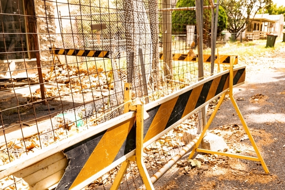 Safety barrier surrounding abandoned building in small rural town - Australian Stock Image