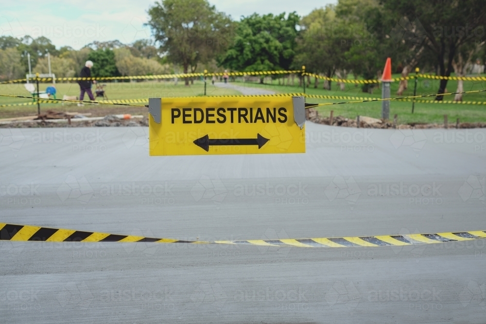Safety black and yellow tape with pedestrians sign at the park - Australian Stock Image