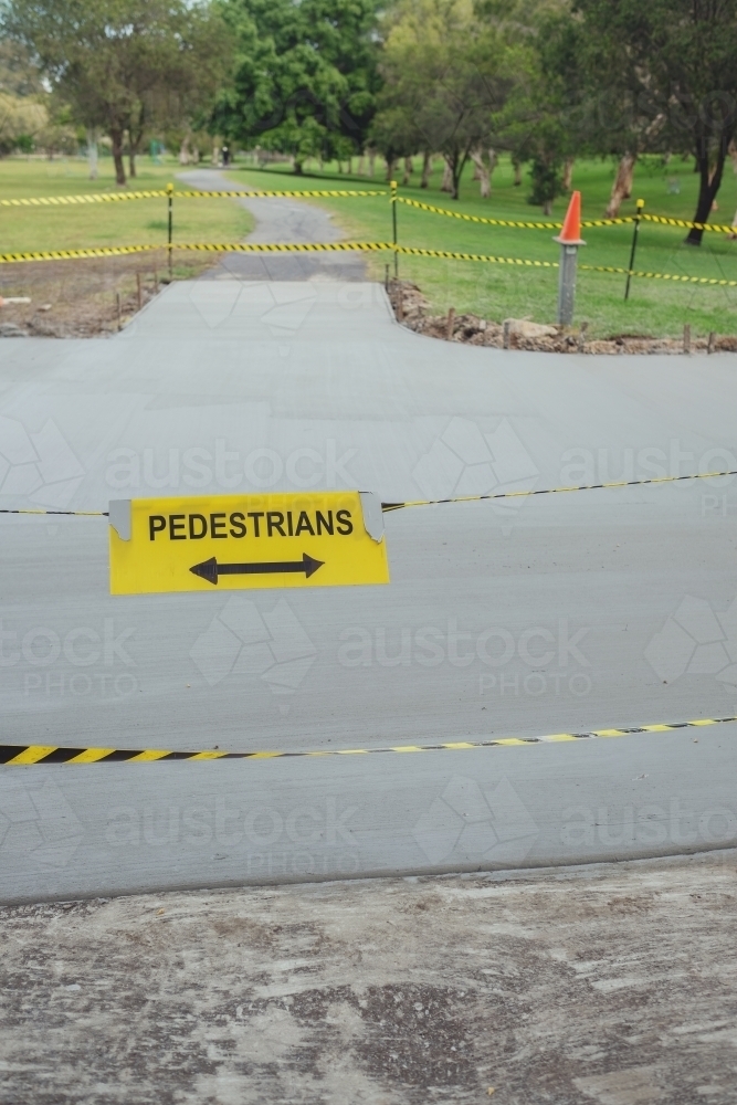 Safety black and yellow tape with pedestrians sign at the park - Australian Stock Image