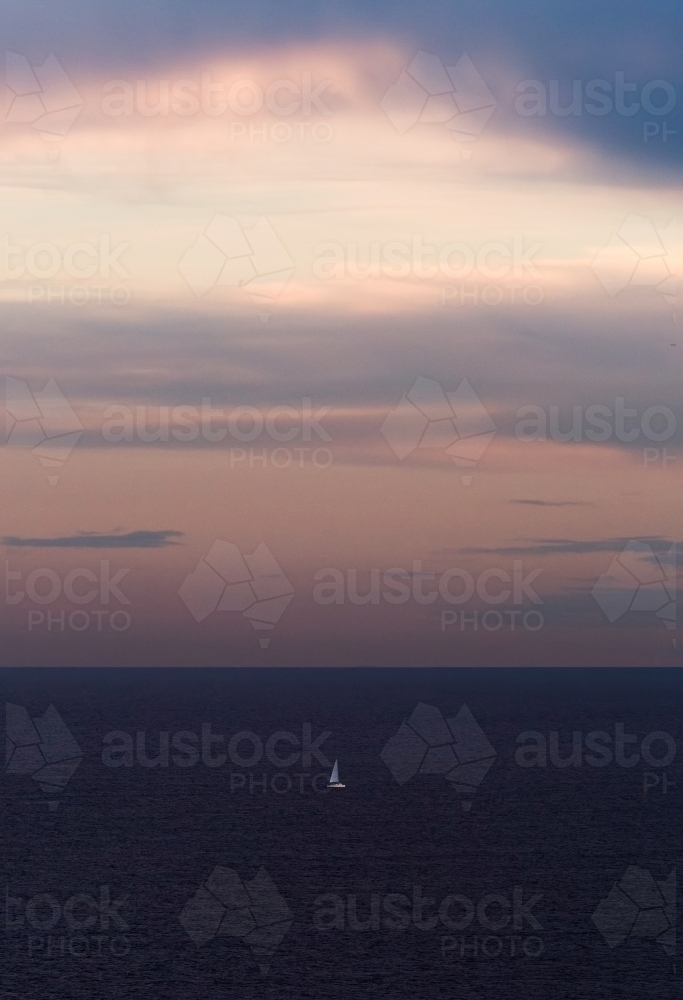Sailboat out at sea at sunset - Australian Stock Image