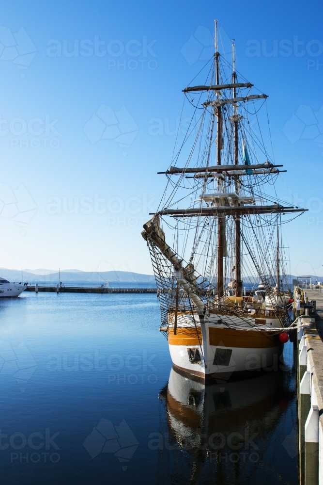 Sailing boat with reflection on still water - Australian Stock Image