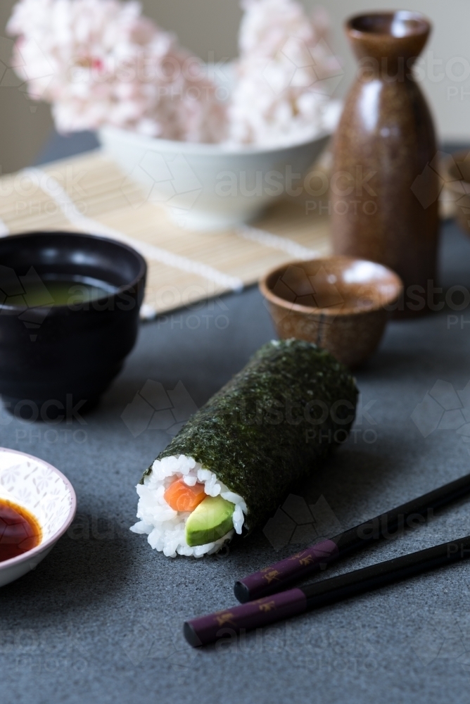 Image of Salmon and avocado sushi roll with green tea and sake