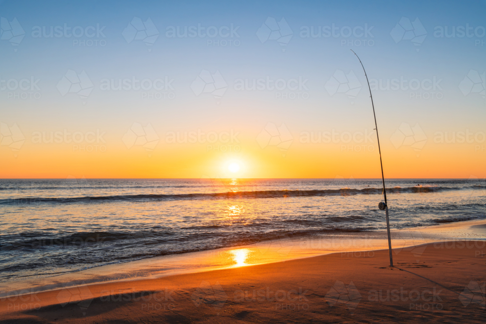 Salmon fishing off the beach at Port Noarlunga during sunset, South Australia - Australian Stock Image