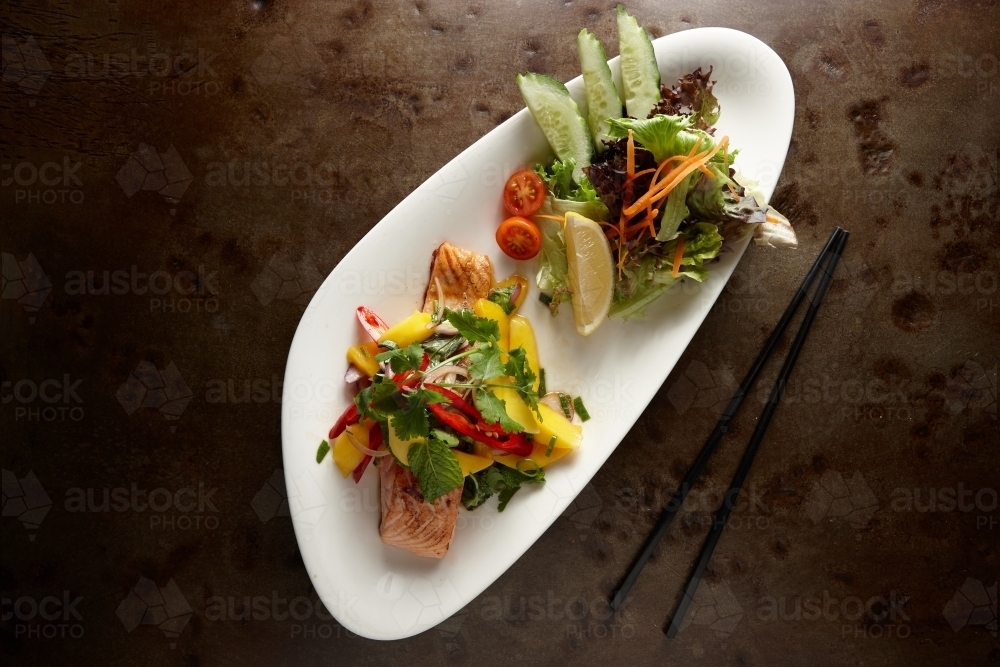 Salmon mango salad dish on table - Australian Stock Image