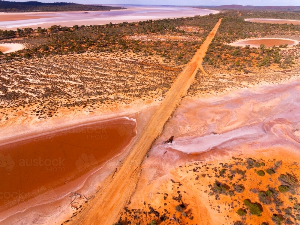 Image of Salt lake with road through outback landscape - Austockphoto