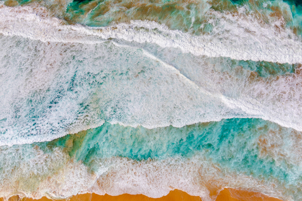 Sand and water mix to form a colourful abstract at Maroubra Beach - Australian Stock Image