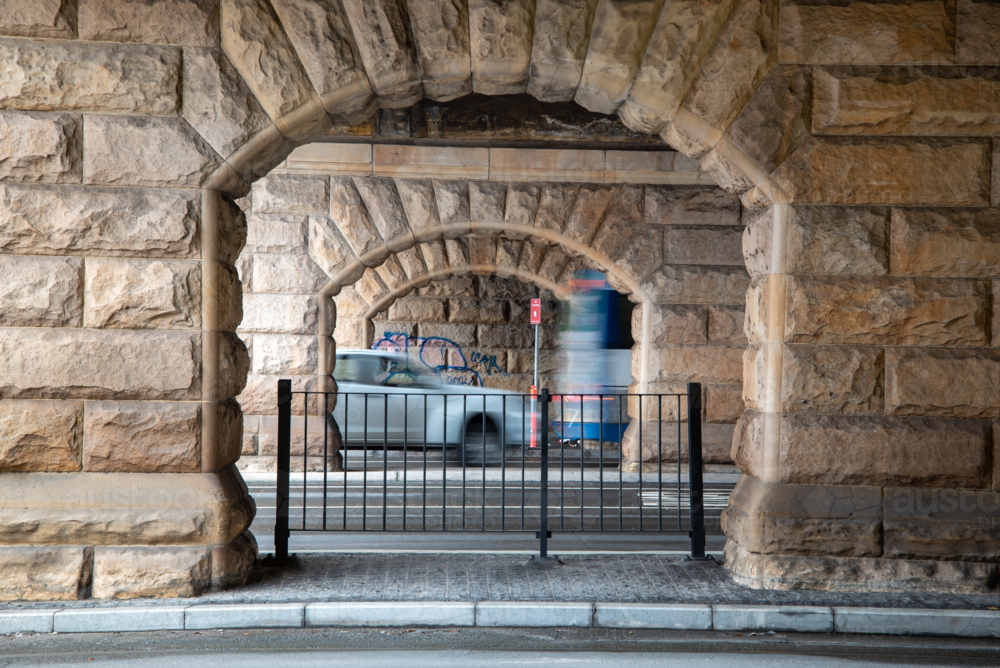 Sandstone arches under bridge with motion blur vehicles - Australian Stock Image