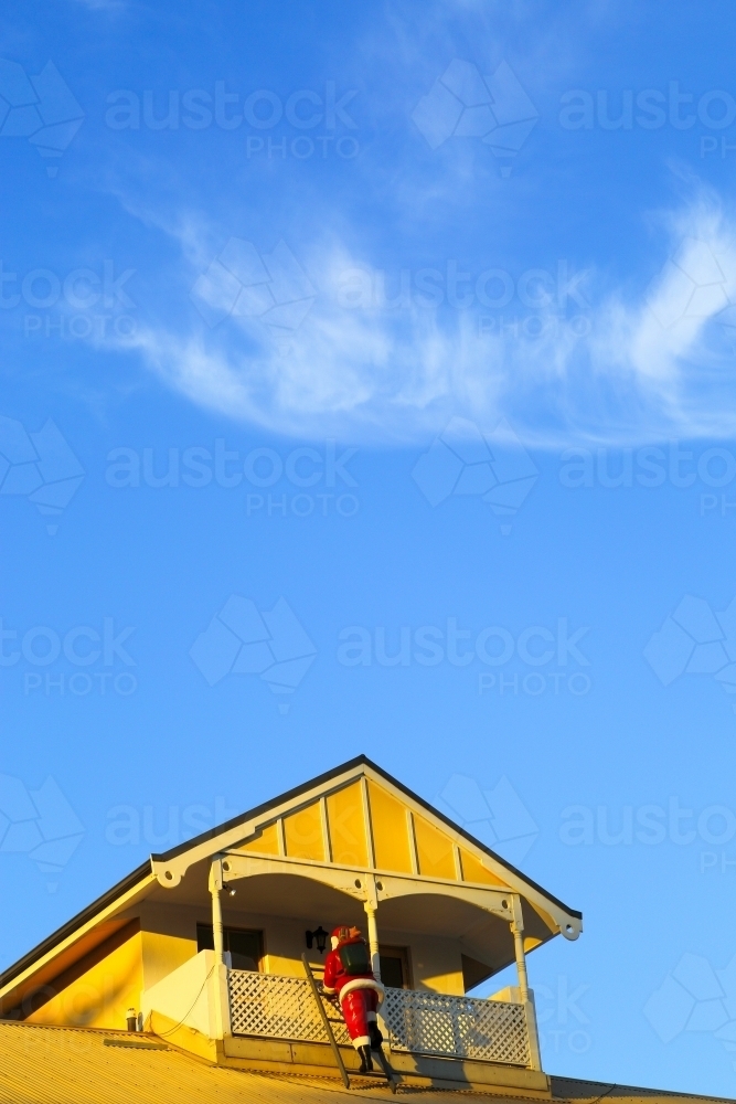 Santa Claus mannequin making his entrance via a balcony during day. - Australian Stock Image