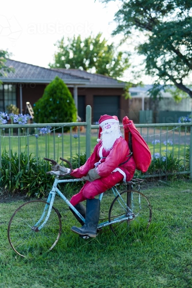 Santa Claus riding a bike christmas decoration - Australian Stock Image