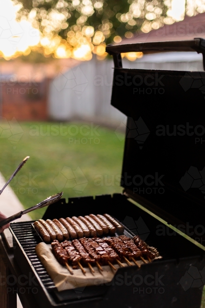 sausages and kebabs cooking on a barbecue hotplate - Australian Stock Image