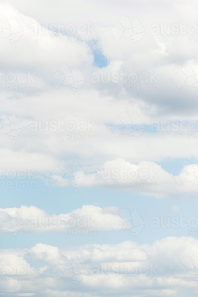 Scattered white clouds in soft blue sky - Australian Stock Image