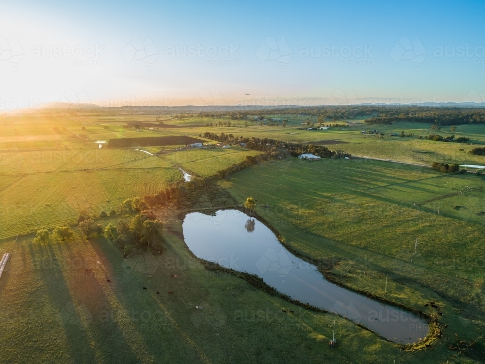 Scenic view of farm paddock with dam at sunset - Australian Stock Image