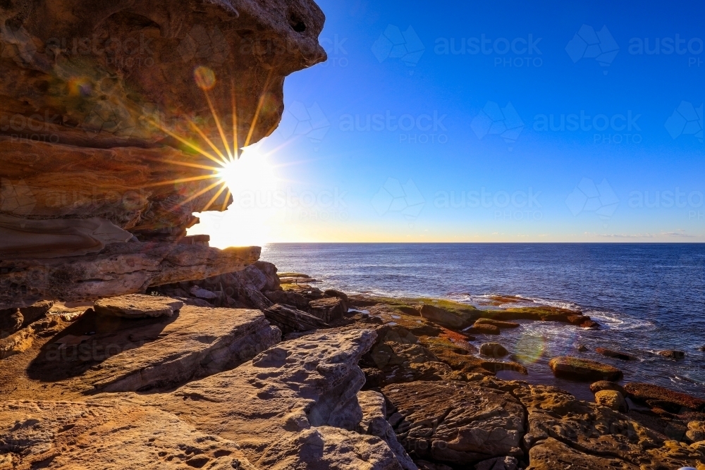 Scenic view of sea against blue sky on rocky coastline - Australian Stock Image