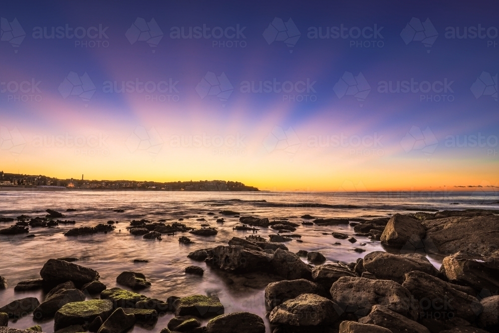 Scenic view of sea against blue sky on rocky coastline - Australian Stock Image