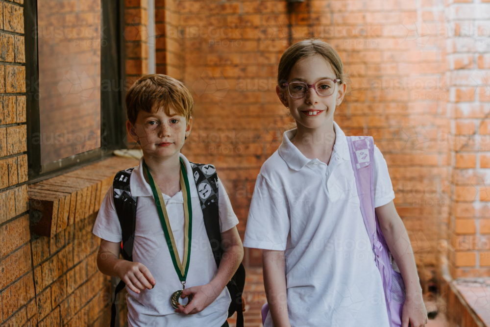 School age kids standing outside building with brick walls - Australian Stock Image