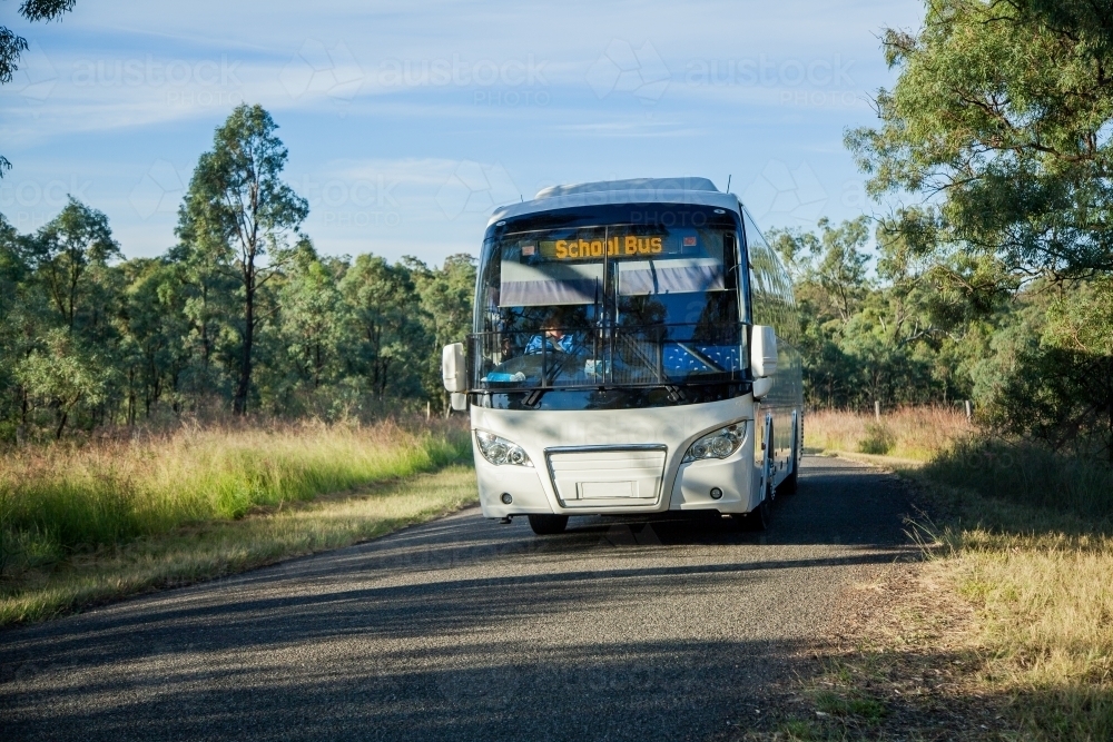 School bus driving down rural country road - Australian Stock Image