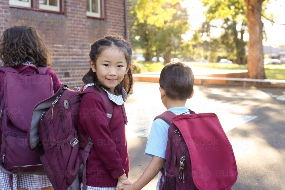 School children holding hands walking in the school yard - Australian Stock Image
