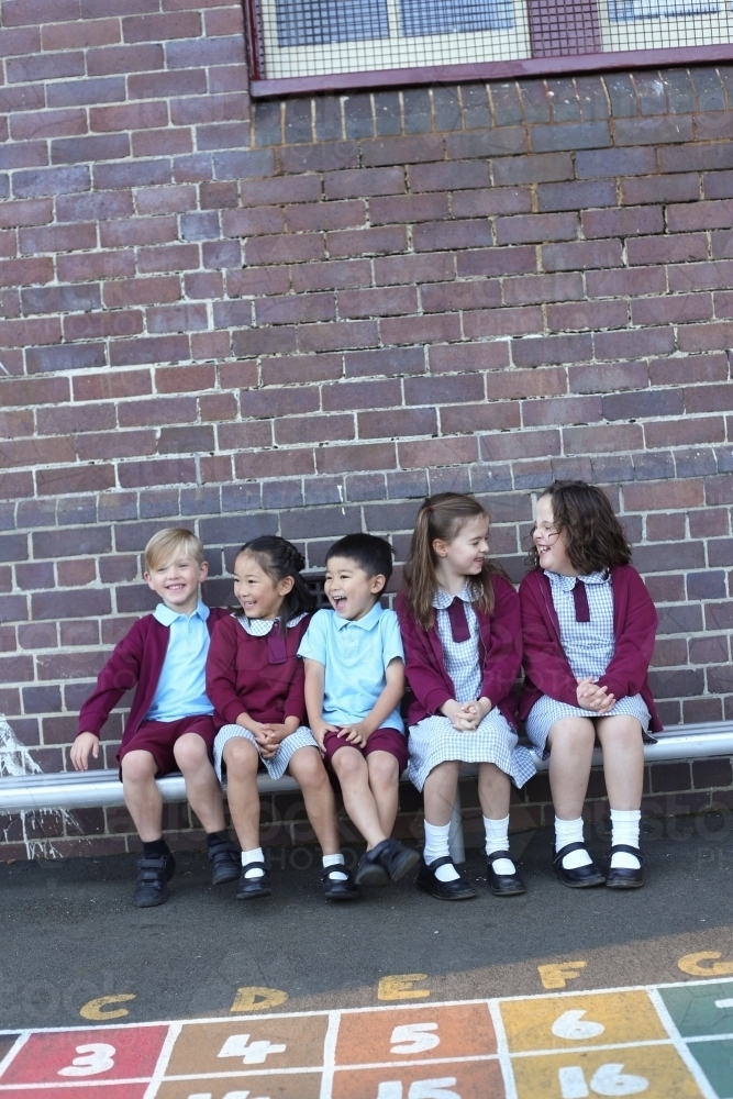 School children sitting outside their school building - Australian Stock Image