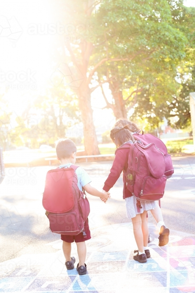 School children walking through playground in the afternoon light - Australian Stock Image