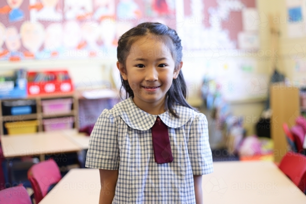 School girl in classroom, smiling at camera - Australian Stock Image