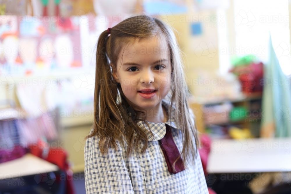 Image of School girl in uniform inside the classroom, smiling ...