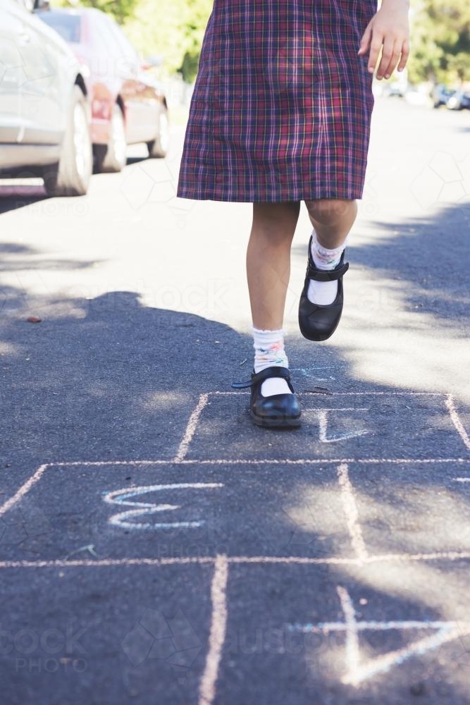 School girl playing hopscotch in the street - Australian Stock Image