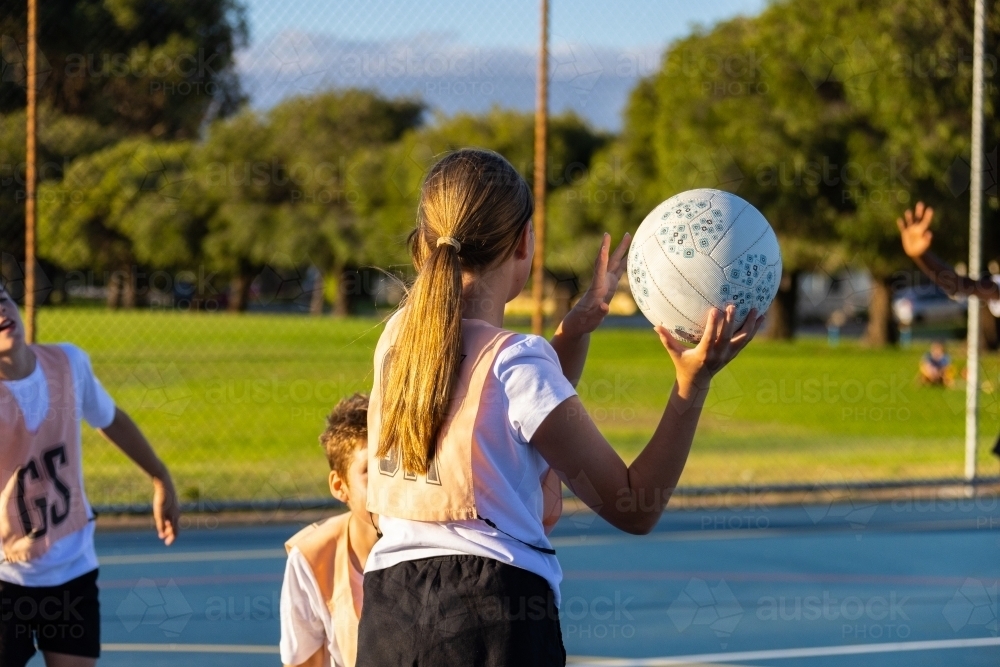 Image of school kids practising netball on outdoor court - Austockphoto