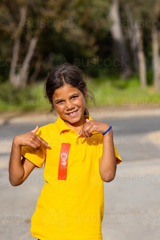 schoolgirl proudly showing off her second place ribbon - Australian Stock Image